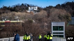 Para polisi berjaga di luar kediaman Presiden Korea Selatan yang dimakzulkan Presiden Yoon Suk Yeol di Seoul, Kamis, 2 Januari 2025. (Foto: Philip Fong/AFP)