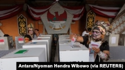 Petugas pemilihan mengenakan pakaian adat Papua saat pemilihan di TPS 17 April 2019. (Foto: Antara/Nyoman Hendra Wibowo via Reuters)