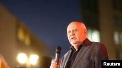 FILE - Former Soviet President Mikhail Gorbachev visits the former Berlin Wall border crossing point Checkpoint Charlie, in Berlin, Nov. 7, 2014. 