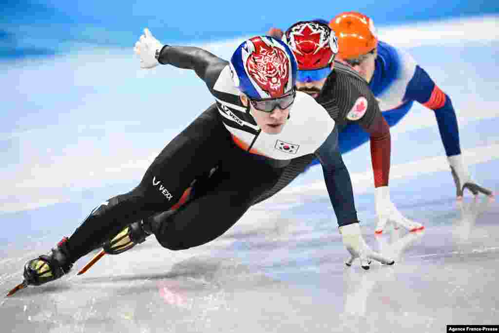 South Korea's Hwang Dae-heon, Canada's Steven Dubois and Russia's Semen Elistratov compete in the final A of the men's 1500m short track speed skating event during the Beijing 2022 Winter Olympic Games at the Capital Indoor Stadium in Beijing.