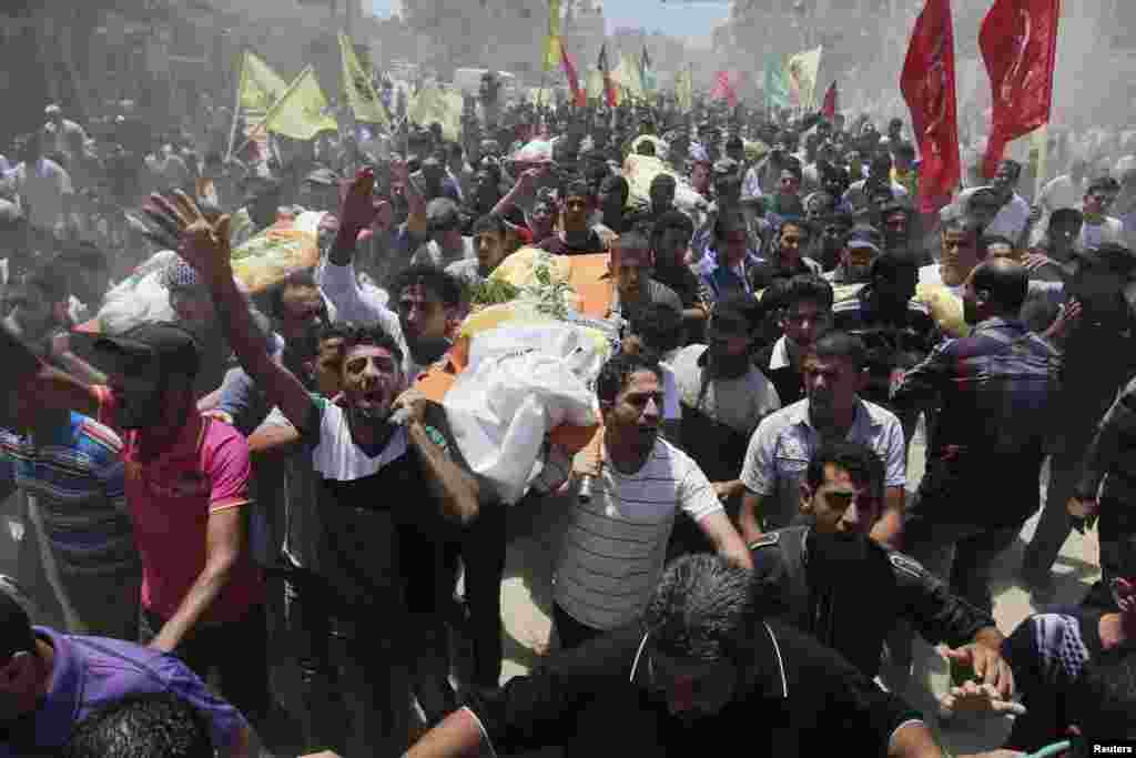 Palestinians carry the bodies of members of the Kaware family that hospital officials said were killed in an Israeli air strike on their house, during their funeral in Khan Younis in the southern Gaza Strip, July 9, 2014.