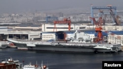 Para tentara angkatan laut Tiongkok terlihat berdiri di atas geladak kapal induk pertama Tiongkok "Lioning" yang berlabuh di pelabuhan Dahlian, propinsi Liaoning, bagian timur laut Tiongkok (25/9).