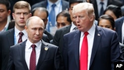 FILE - U.S. President Donald Trump and Russia's President Vladimir Putin talk during the family photo session at the APEC Summit in Danang, Vietnam, Nov. 11, 2017.