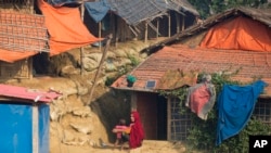 A Rohingya Muslim refugee sunbathes along with her child outside their shelter at Balukhali refugee camp near Cox's Bazar, in Bangladesh, Saturday, Nov. 17, 2018. 