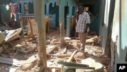 A man stands amid the debris at the scene of an attack in the town of Mandera, Kenya, near the border with Somalia, Oct. 25, 2016. 