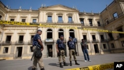 Municipality police guard the National Museum which burned the previous night in Rio de Janeiro, Sept. 3, 2018. 
