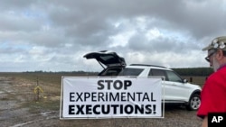 Activistas contra la pena de muerte colocan carteles a lo largo de la carretera que conduce al Centro Correccional Holman en Atmore, Alabama, antes de la ejecución programada de Kenneth Eugene Smith el 25 de enero de 2024 en Estados Unidos