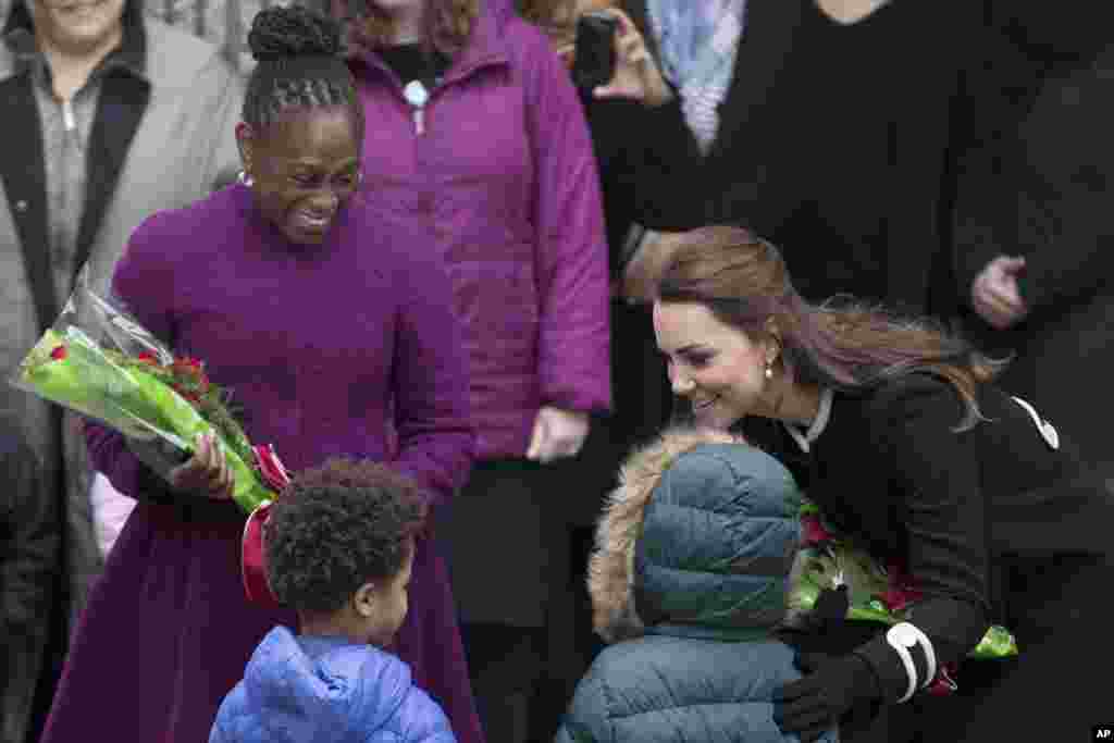 Chirlane McCray, première dame de New York City, et Catherine, duchesse de Cambridge, reçoivent des fleurs des élèves à l'extérieur du centre Northside for Child Development, à New York, le 8 décembre 2014.