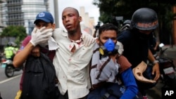 Los paramédicos asisten a un hombre herido durante las protestas y enfrentamientos entre las fuerzas de seguridad y la oposición. 