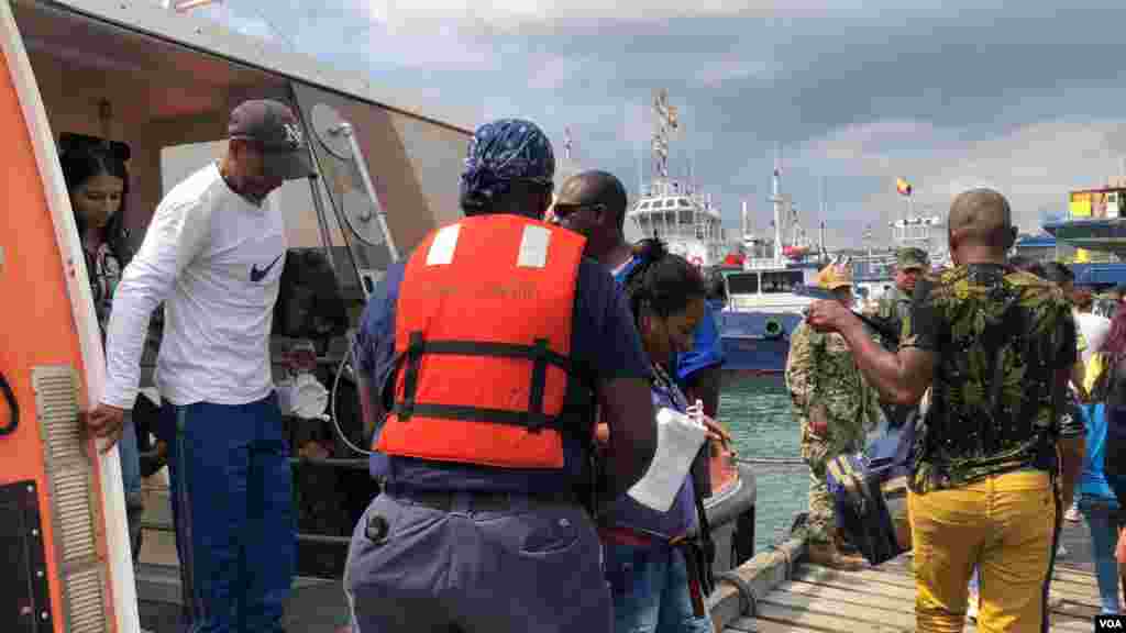 Funcionarios ayudan a un joven que regresa del buque hospital USNS Comfort a Esmeraldas, un puerto relativamente cercano a Quito, la capital de Ecuador. Este jueves regresó el primer grupo de 40 pacientes que recibieron tratamiento quirúrgico gratuito en el barco estadounidense.