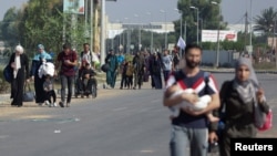 Warga sipil Palestina berjalan kaki untuk mengungsi dari bagian utara Jalur Gaza ke selatan di tengah perang antaran Israel dan kelompok Hamas Palestina, di tengah Kota Gaza, 7 November 2023. (Foto: Ahmed Zakot/Reuters)
