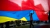 Un joven camina bajo una gran bandera venezolana durante un mitin organizado por trabajadores de la Compañía Nacional de Telecomunicaciones o CANTV para mostrar su apoyo al gobierno en Caracas, Venezuela. [Foto del 25 de fe]