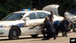 Gambar dari televisi lokal WRCB-TV memperlihatkan pihak berwajib mengepung lokasi dekat jalan raya Amincola dekat Naval Reserve Center di Chattanooga, Tennessee (16/7).