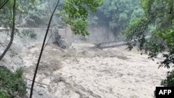An image taken from video on Oct. 5, 2023, shows a damaged steel bridge over the flooded Teesta River in north Sikkim's Chungthang region of India. The death toll from a glacial lake burst that triggered a torrential flash flood has risen to at least 47 people. (Indian Army/AFP)