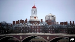 FILE - Rowers paddle down the Charles River past the campus of Harvard University in Cambridge, Mass., March 7, 2017. A federal judge in Boston heard closing arguments Friday in a highly publicized lawsuit alleging that elite Harvard discriminates against