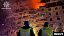 Petugas polisi berdiri di depan gedung apartemen yang rusak akibat serangan rudal Rusia, di tengah serangan Rusia ke Ukraina, di Kryvyi Rih, wilayah Dnipropetrovsk, Ukraina, 12 Maret 2024. (Foto: via Reuters)