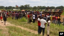 People fleeing ongoing violence gather near a French armored personnel carrier as they seek security at the airport in Bangui, Central African Republic, Aug. 29, 2013.