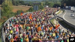 Demonstrators walk along a highway in Girona, Spain, Oct. 16, 2019. 