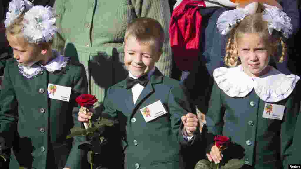 First-grade pupils attend a festive ceremony to mark the beginning of another academic year in Makiivka, eastern Ukraine, Oct. 1, 2014.