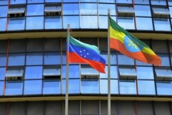 FILE - The unofficial flag of the advocated region for the Sidama ethnic group, left, flies next to the Ethiopian national standard as local elders planned to declare the establishment of a breakaway region, in Hawassa, July 15, 2019.