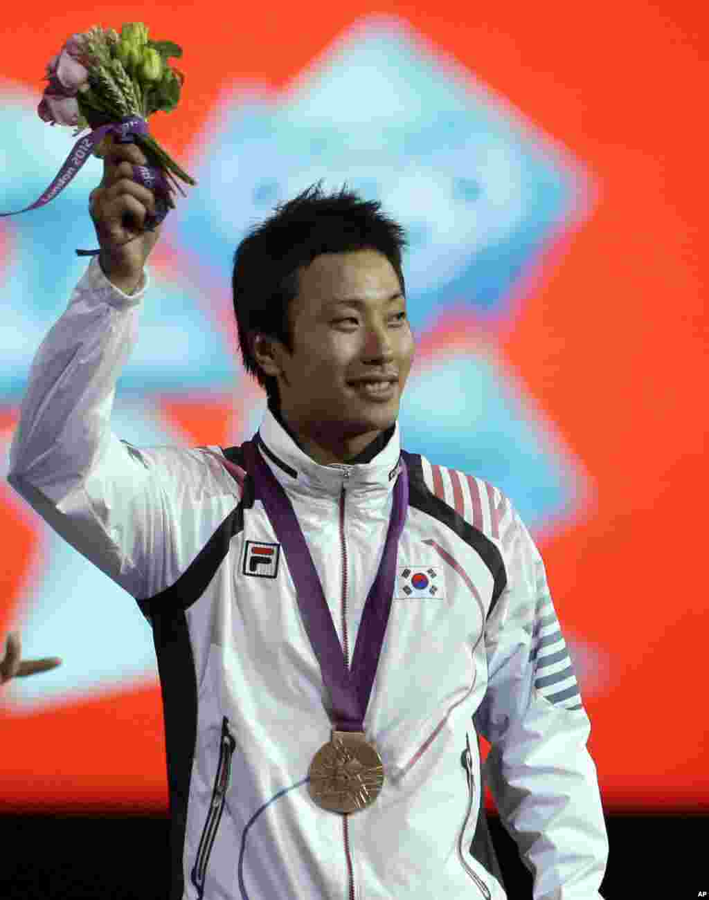 Bronze medalist Choi Byungchul of South Korea, waves to the crowd during the medals ceremony after the men's individual foil fencing competition at the 2012 Summer Olympics, July 31, 2012, in London.
