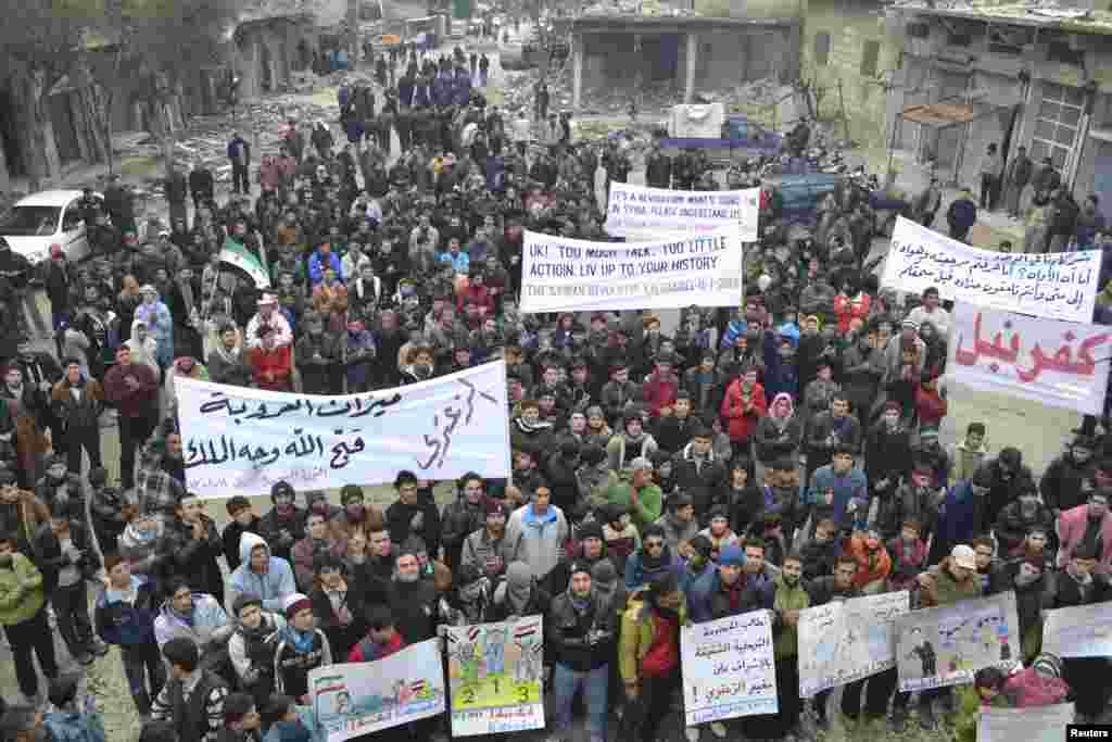 Demonstrators hold banners during a protest against Syria's President Bashar al-Assad, after Friday prayers in Kafranbel, near Idlib, Syria, January 11, 2013 in this picture provided by Shaam News Network.