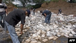 Miembros de la policía destruyen paquetes de drogas en el vertedero de basura Cerro Patacón en Ciudad de Panamá, el 09 de diciembre de 2005.