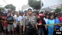 Polisi berjaga di sekitar lokasi serangan bom di gereja GBIS Solo, sementara masyarakat setempat ikut menonton (25/9). Aksi teror di Indonesia dikhawatirkan menjadi ideologi perlawanan anti kemapanan.
