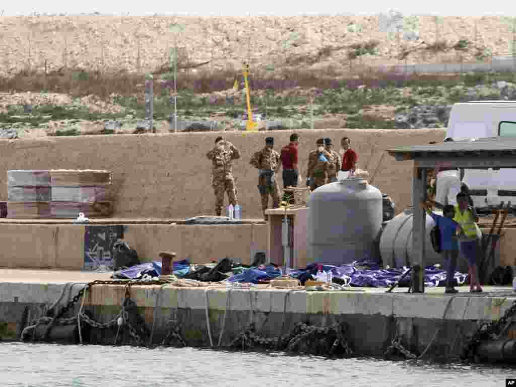 Bodies of drowned migrants are lined up in the port of Lampedusa. A ship carrying African migrants to Europe caught fire and capsized off the Italian island, spilling hundreds of passengers into the sea, officials said. Over 150 people were rescued but some 200 others were still unaccounted-for.
