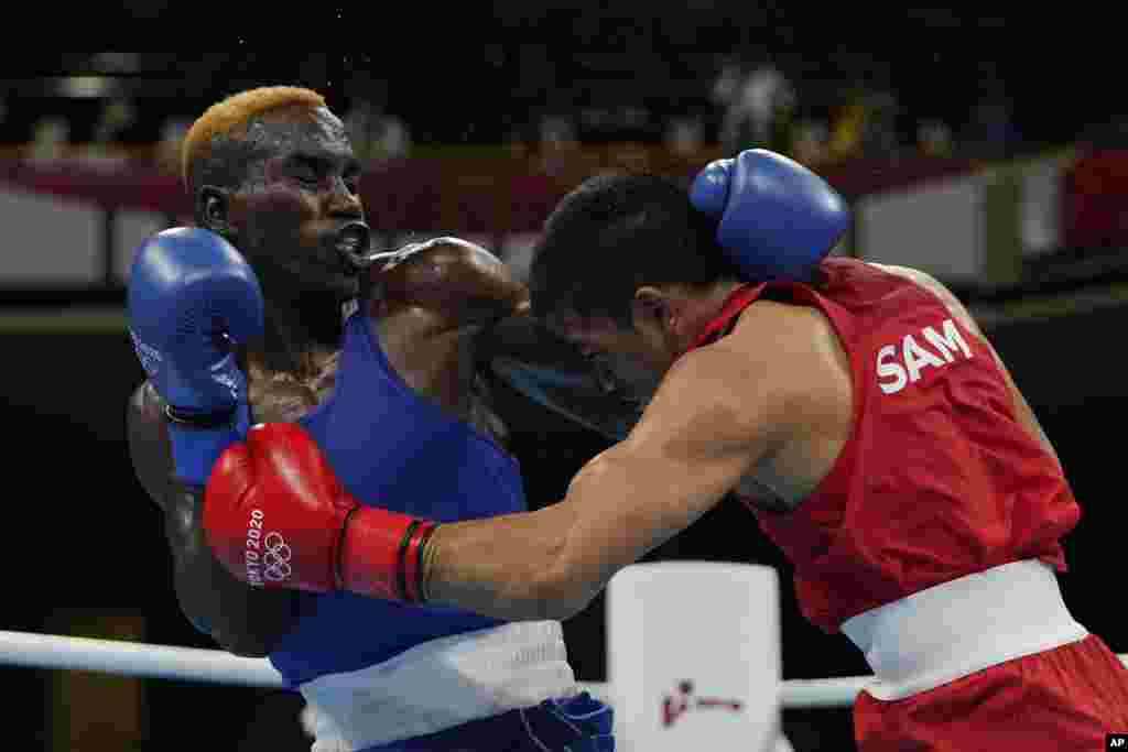 Samoa's Marion Faustino Ah Tong, right, exchanges punches with Zambia's Stephen Zimba during their men's welterweight 69-kg boxing match at the 2020 Summer Olympics, Saturday, July 24, 2021, in Tokyo, Japan. (AP Photo/Frank Franklin II, Pool)