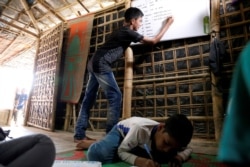 FILE PHOTO: Mohammed Tuahayran, 17, teaches English in a makeshift school at Kutupalong refugee camp in Cox’s Bazar, Bangladesh, Feb. 7, 2019.