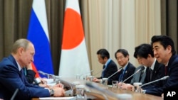 资料照片：2014年2月8日，俄罗斯总统普京（左）和日本首相安倍（右）在俄罗斯索契会晤。