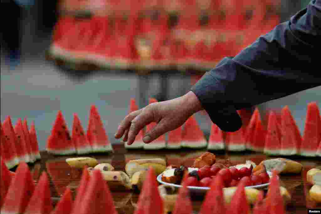 Seorang pria mengambil makanan menjelang buka puasa bersama kaum Muslim di masjid bersejarah Niujie di Beijing, China.