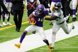 FILE - Minnesota Vikings wide receiver Justin Jefferson, left, tries to break a tackle by Tennessee Titans inside linebacker Jayon Brown during the first half of an NFL football game in Minneapolis, Sept. 27, 2020.