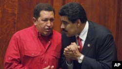 ARCHIVO - El presidente de Venezuela, Hugo Chávez, a la izquierda, habla con el entonces ministro de Relaciones Exteriores, Nicolás Maduro, en Montevideo, Uruguay, el 18 de diciembre de 2007.
