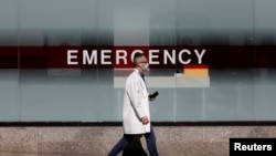 Seorang dokter mengenakan masker di luar Rumah Sakit Mount Sinai di Manhattan di tengah wabah virus corona di New York City, 1 April 2020. 