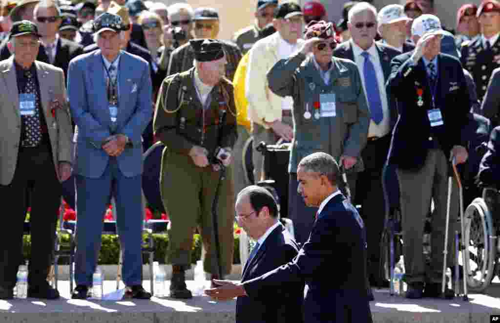 U.S. President Barack Obama and French President Francois Hollande walk by veterans and participants at a D-Day ceremony at the Normandy American Cemetery and Memorial in Colleville-sur-Mer, France, June 6, 2014.
