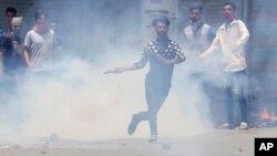 A Kashmiri Muslim protester throws back a teargas shell at Indian paramilitary soldiers in Srinagar, Indian-controlled Kashmir, July 10, 2016.