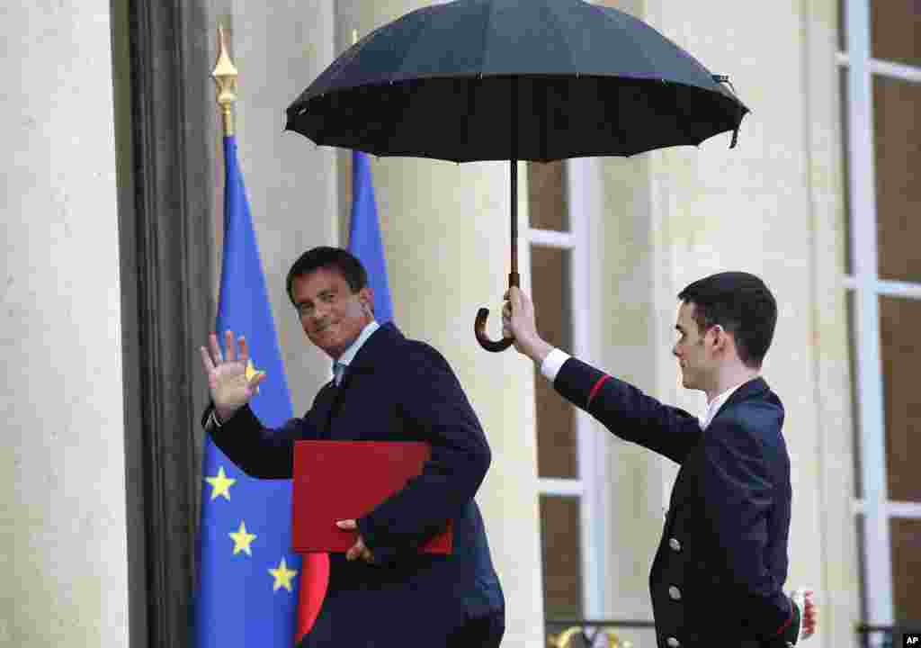 French Prime Minister Manuel Valls (left) waves as he arrives for a meeting with French President Francois Hollande at the Elysee Palace in Paris, Aug. 25, 2014. 