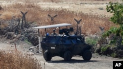 Un soldado turco junto a un vehículo blindado vigilando una carretera cerca de la frontera con Siria, el viernes, 24 de julio de 2015.