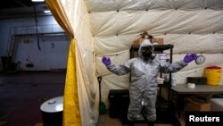 FILE - A U.S. MV Cape Ray ship staff member wearing personal protective equipment is seen at the naval airbase in Rota, near Cadiz, southern Spain.
