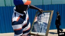 Moto moko amemi photo ya nkondo Robert Mugabe, président ya kala ya Zimbabwe, na bozongi ya nzoto ya ye, na libanda ya mpepo na Harera, 11 septembre 2019.