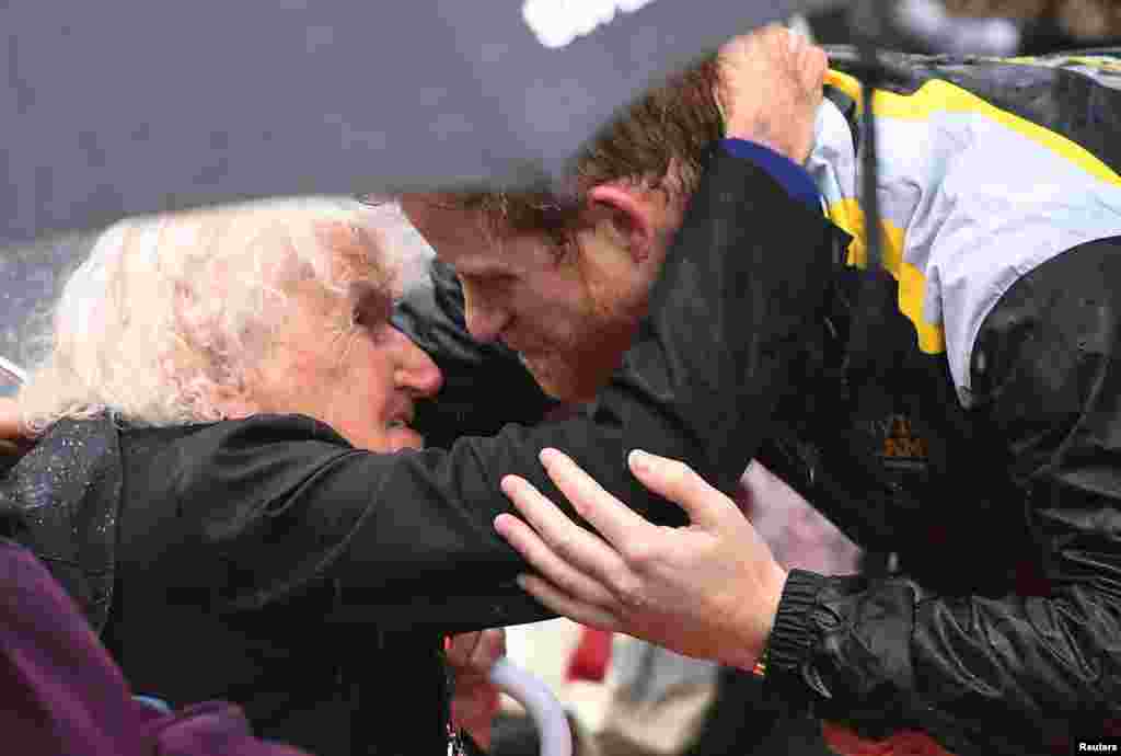 Britain's Prince Harry hugs Daphne Dunne, 97, during a walk around The Rocks district in rainy Sydney, Australia, during his promotion of the 2018 Invictus Games.