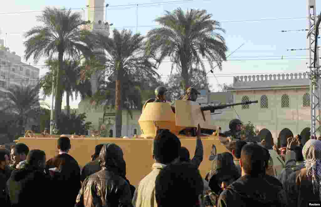 Supporters of the Muslim Brotherhood welcome tanks arriving outside the Egyptian presidential palace in Cairo, December 6, 2012.