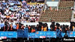 سنکیانگ میں مجرموں و مشتبہ افراد کو سرعام سزا سنانے متعلق تقریب میں ٹرکوں پر لایا جا رہا ہے۔ (فائل فوٹو)