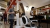 Workers wearing face masks to prevent the spread of COVID-19 prepare for the opening of a barbershop, in Rome, May 16, 2020. 