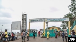 FILE - People walk by the entrance to the Yaounde General Hospital, in Yaounde, Cameroon, March 6, 2020. 