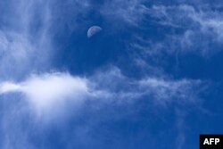 The moon is pictured during a cloudy day over Saint-Philbert-sur-Risle on August 8, 2023. (Photo by JOEL SAGET / AFP)