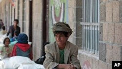 file - A boy waits for food supplies provided by the World Food Program at a school in Sana'a, Yemen, Aug. 25, 2019.