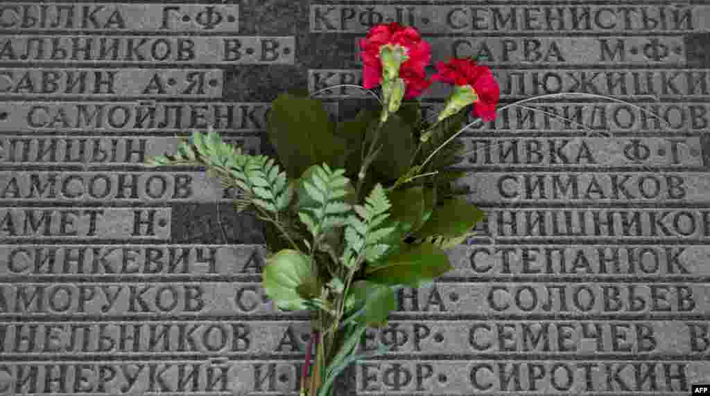 Flowers lay on a plaque engraved with the names of Soviet casualties at a Soviet war memorial in a cemetery for killed Soviet soldiers on the occasion of the 70th anniversary of the end of WWII, in Lebus, eastern Germany, May 8, 2015.